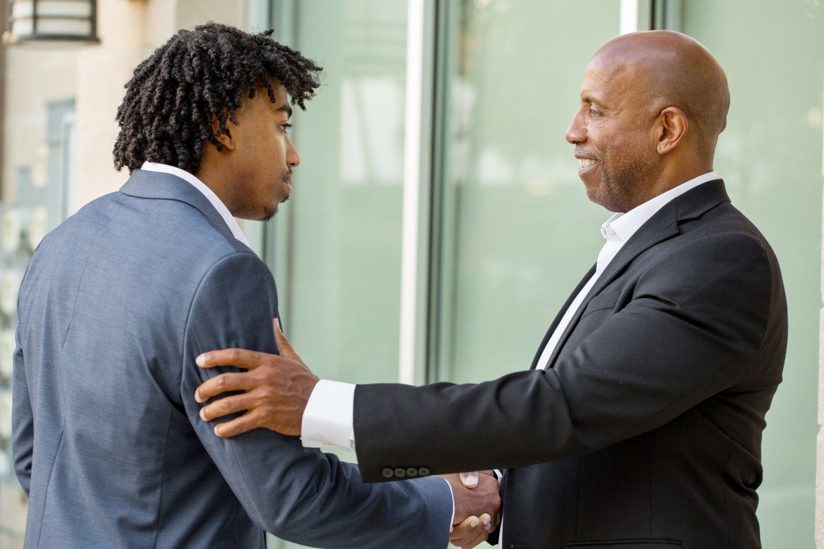 older black man shakes hand of younger black man/mentor220466106