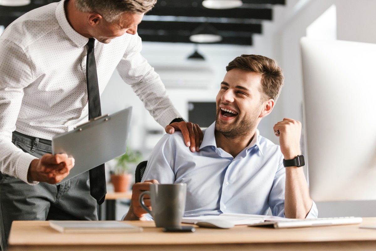 older man puts hand on younger man's shoulder as they laugh/mentor223157767