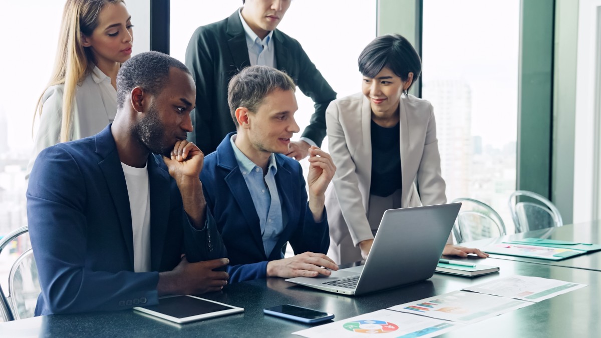 Diverse group of colleagues around a laptop 469844198