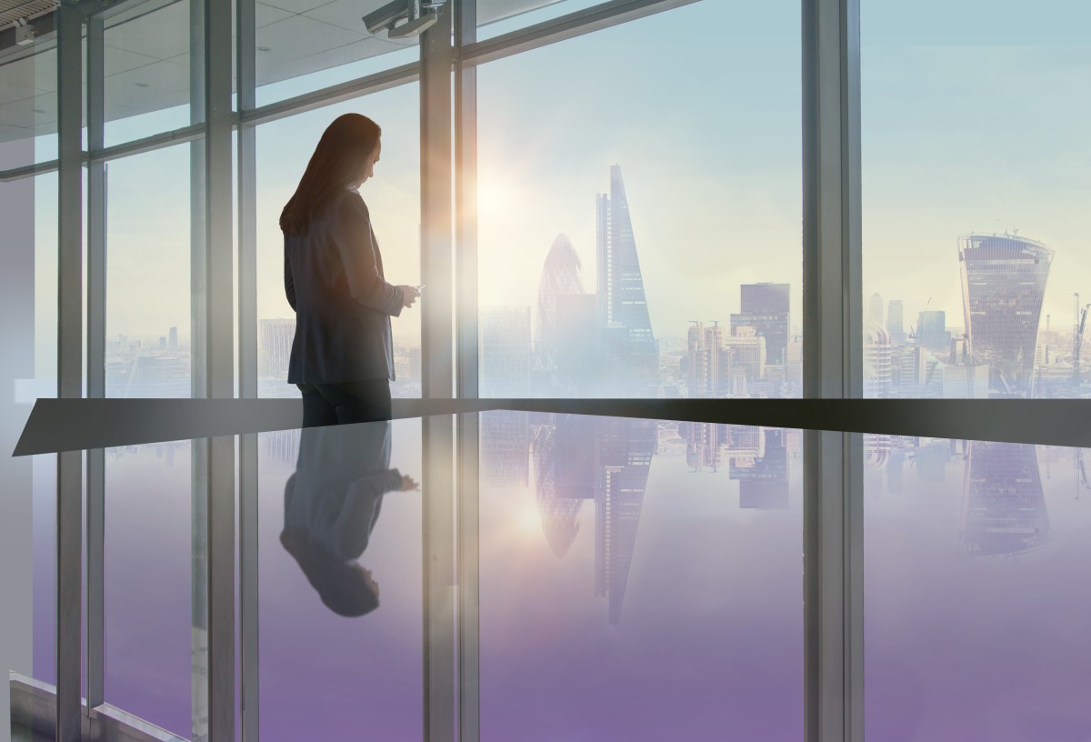 woman stands in front of large window with cityview 257520544